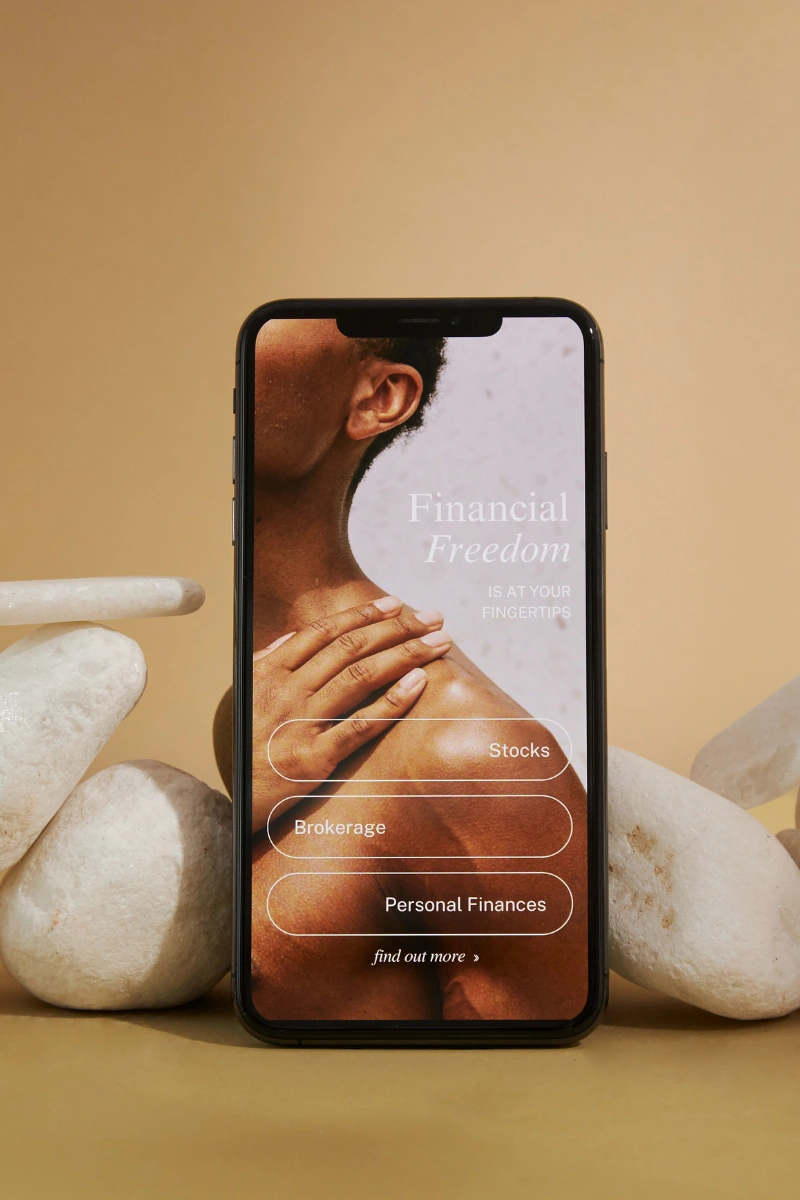 Smartphone displaying a financial freedom app interface with options for stocks, brokerage, and personal finances.
