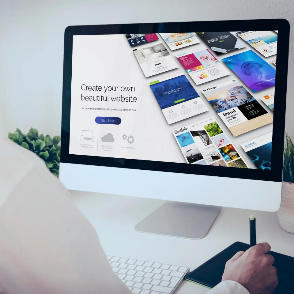 Person using computer displaying website builder with template gallery showing 'Create your own beautiful website' message