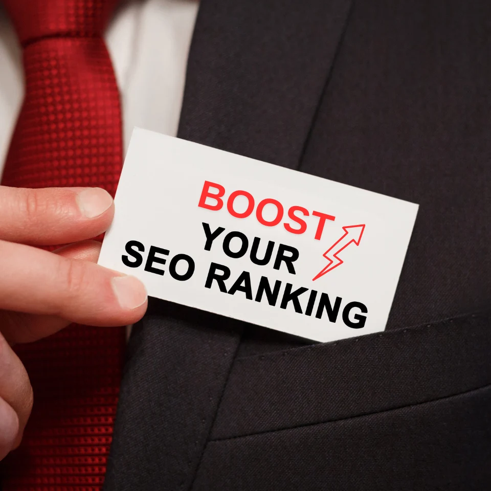 Businessman holding a card with the text 'Boost Your SEO Ranking' in a suit and red tie